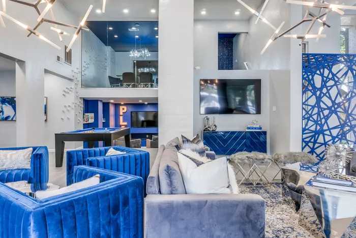 Leasing office with grey couch, blue chairs, and TV