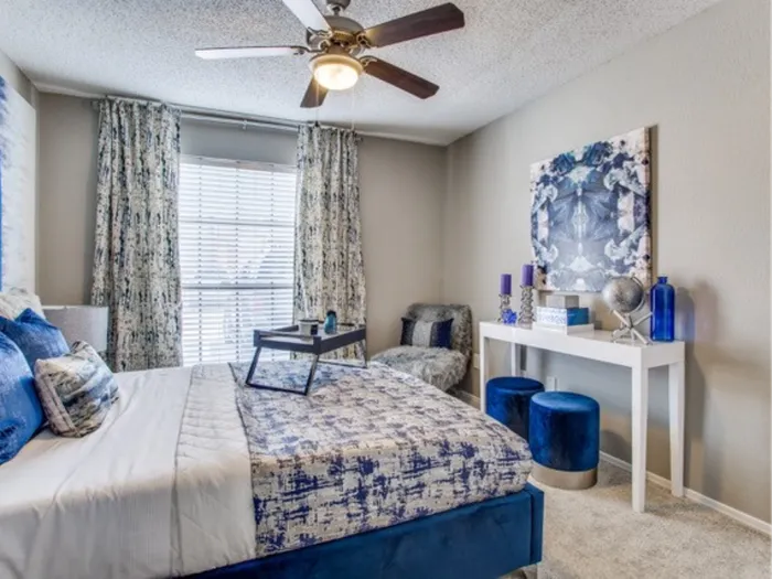 Carpeted bedroom with ceiling fan and large window