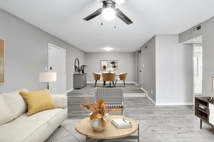 Living space with wood floors, ceiling fan, and chair.