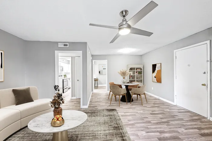 Living space with wood floors, ceiling fan, and chair.