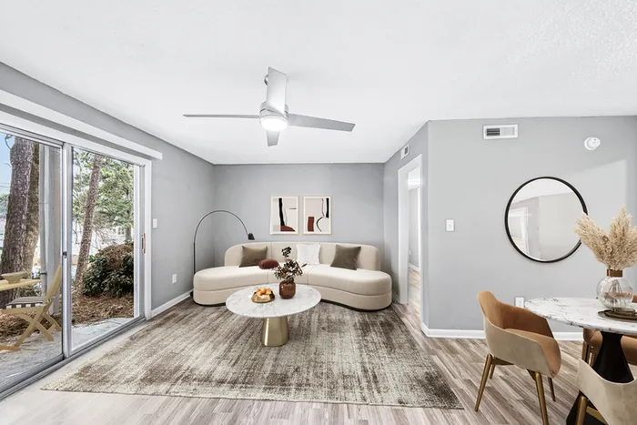 Living space with wood floors, ceiling fan, and couch
