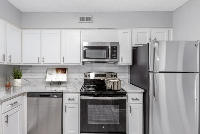 Vinyl floors, stainless-steel appliances, white quartz countertop