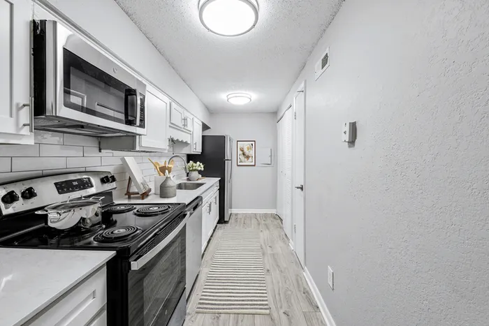 Vinyl floors, stainless-steel appliances, white quartz countertop