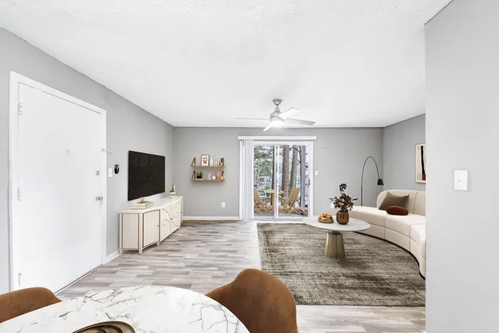 Living space with wood floors, ceiling fan, TV, and couch