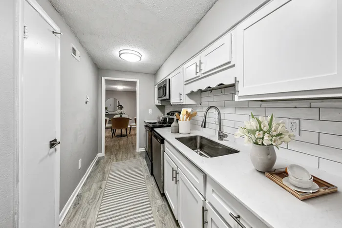 Vinyl floors, stainless-steel appliances, white quartz countertop
