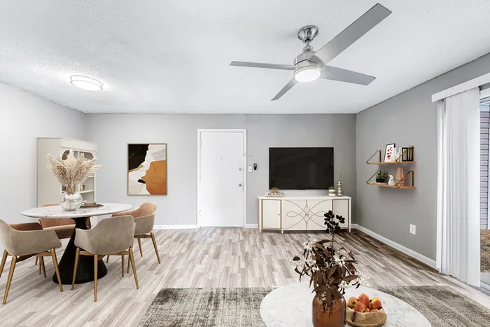 Living space with wood floors, ceiling fan, TV, and couch