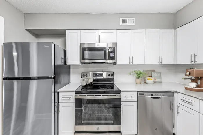 Vinyl floors, stainless-steel appliances, white quartz countertop