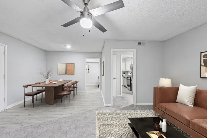 Living space with wood floors, ceiling fan, TV, and couch