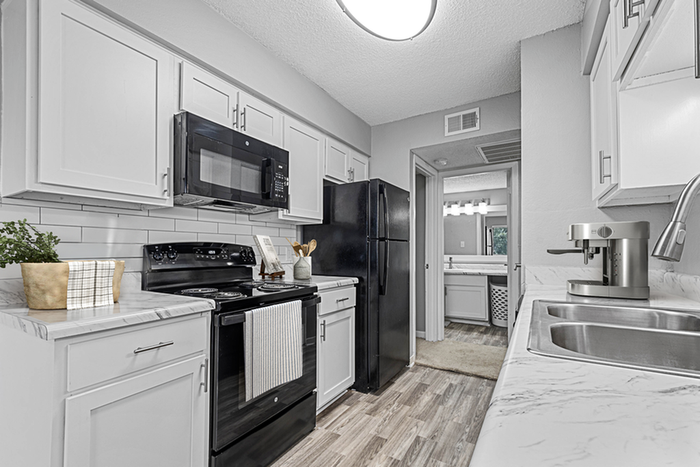 Kitchen with Vinyl floors, stainless-steel appliances, white quartz countertop