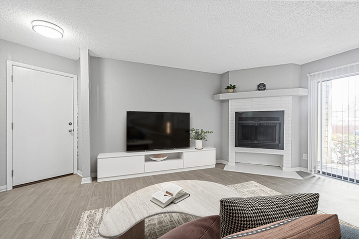 Living room with wood floor, fireplace, and TV