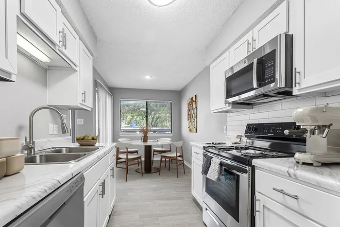 Kitchen with Vinyl floors, stainless-steel appliances, white quartz countertop