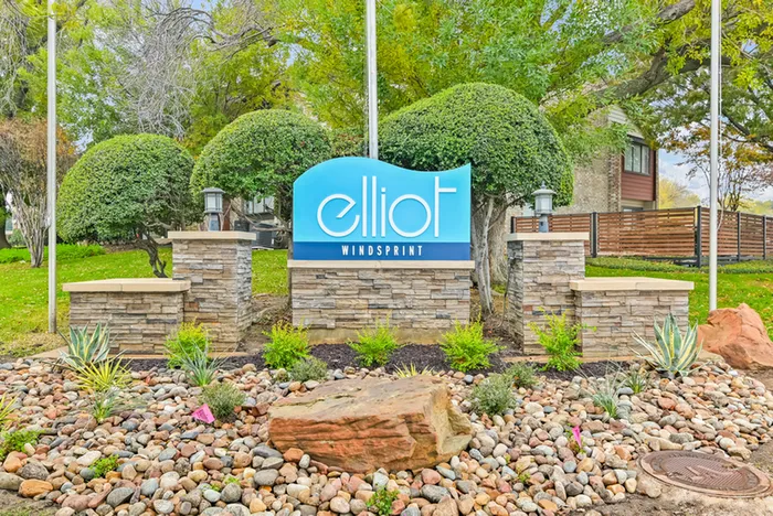 Monument sign on brick surrounded by landscaping