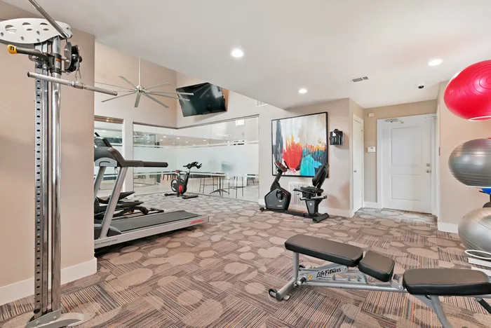 Fitness center with TV, bench, and cardio equi[ment