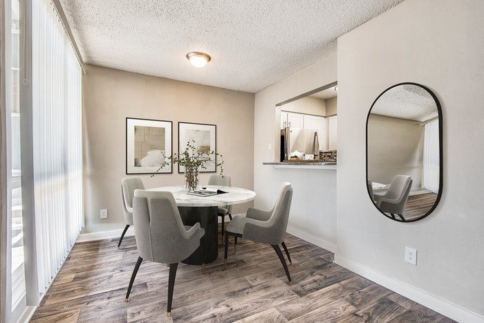 Dining nook, hard wood style flooring, rounded wall mirror, rectangular wall art