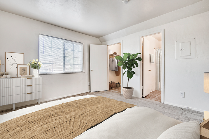 Bedroom, hardwood flooring, queen-size bed with tan bedding b