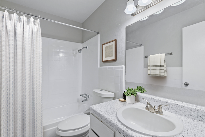 Bathroom with vanity lighting, granite countertops, toilet, bathtub