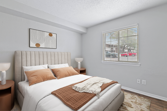 Bedroom, hard wood flooring, queen bed with beige fabric framing, wooden end table with lamp
