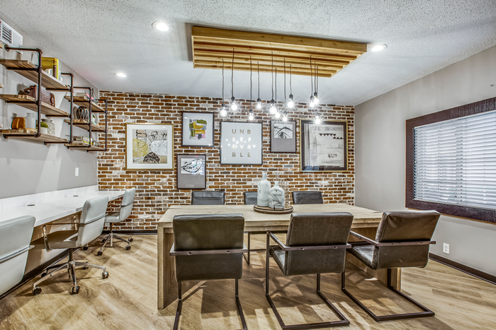 Resident lounge dining table with pendant lighting and wall art
