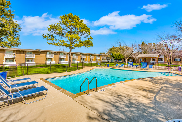 Pool, sundeck, blue lounge chairs, apartment exterior