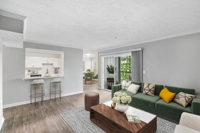 Living space with vinyl flooring, coffee table, couch, and large patio window.