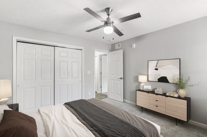 Virtual staging of bedroom with large bed and ceiling fan