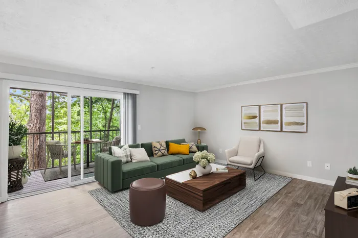 Living space with vinyl flooring, coffee table, couch, and large patio window.
