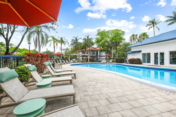 Pool with lounge chairs on sundeck, exterior of community building