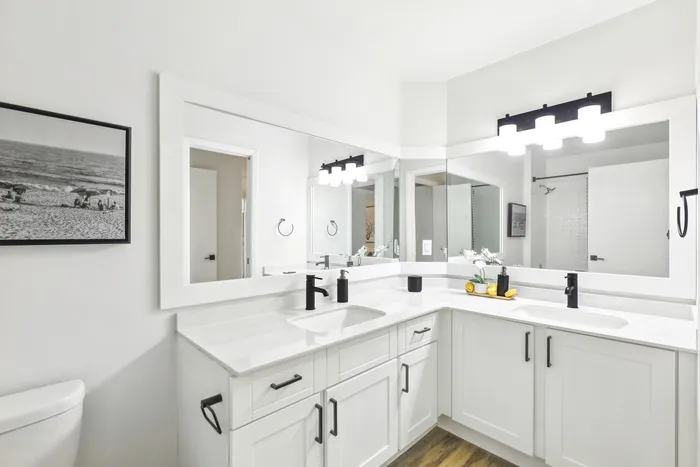 Renovated bathroom, extended vanity mirror with vanity lighting, white cabinetry