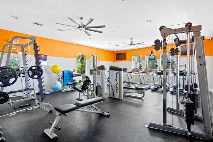 fitness center smith machine, bench, yoga balls, ceiling fans, flat screen TV, treadmills