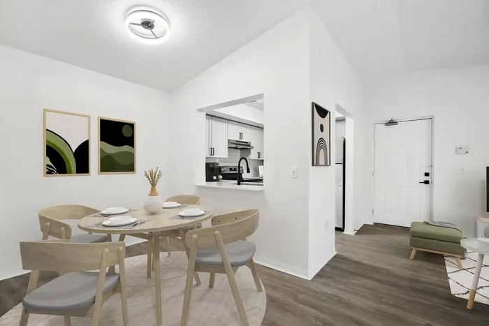 Dining area with wooded table and chairs, hardwood style flooring, wall opening to kitchen