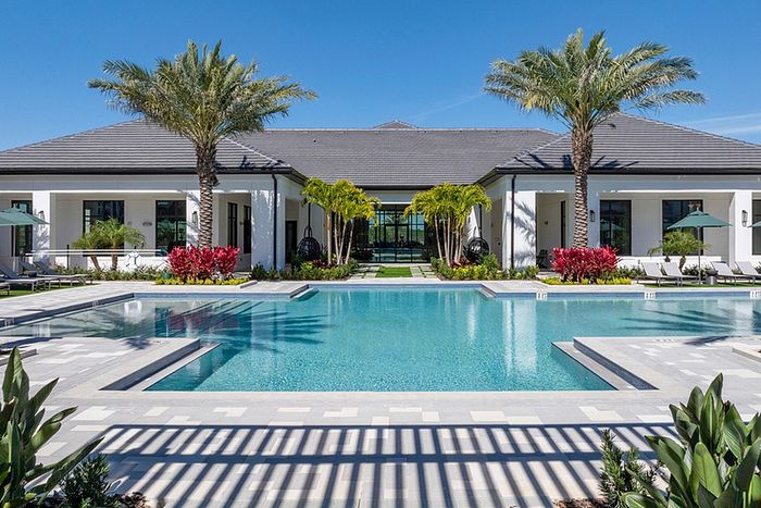 Expansive pool, sundeck, lounge chairs and palm trees