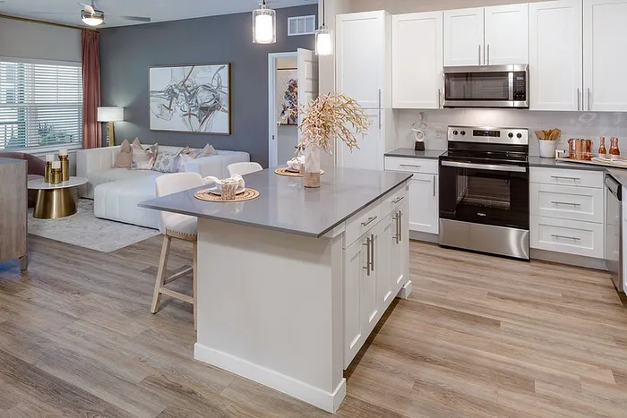 Renovated kitchen with white cabinets and wood style flooring