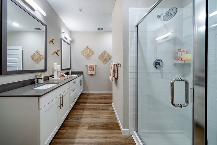 Renovated bathroom with white cabinets and wood style flooring