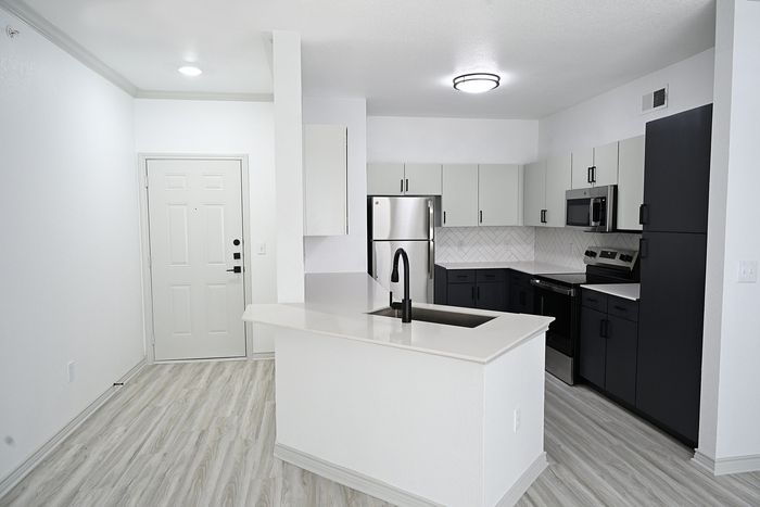 Contemporary apartment featuring a stylish kitchen with modern appliances, open layout, and sleek flooring.