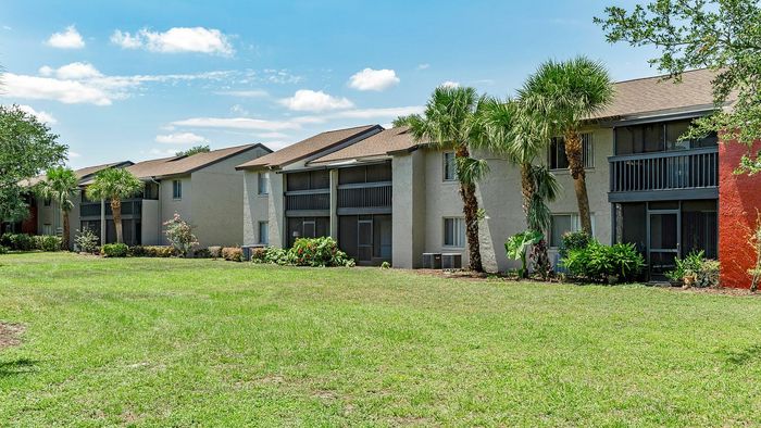 Charming apartment complex with lush greenery and palm trees, offering serene living spaces and sunny balconies.