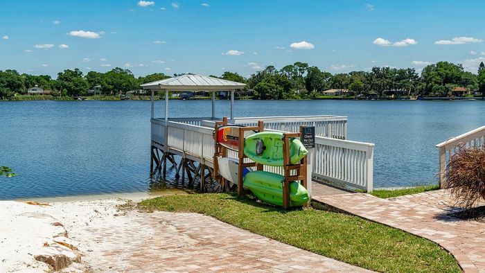 Picturesque waterfront view with a charming lakeside gazebo and kayak rentals, perfect for outdoor enthusiasts.