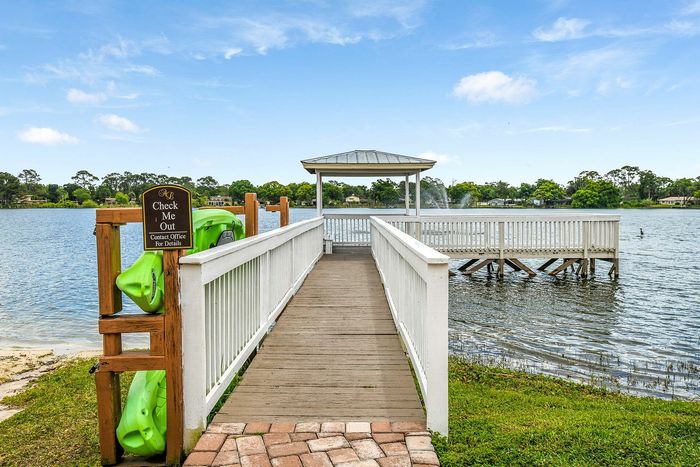 Inviting lakeside view featuring a charming wooden gazebo at the end of a scenic boardwalk, perfect for relaxation and enjoying serene waterside moments.