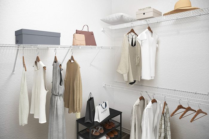 Spacious walk-in closet with elegant shelving, stylish clothes, and ample storage space.