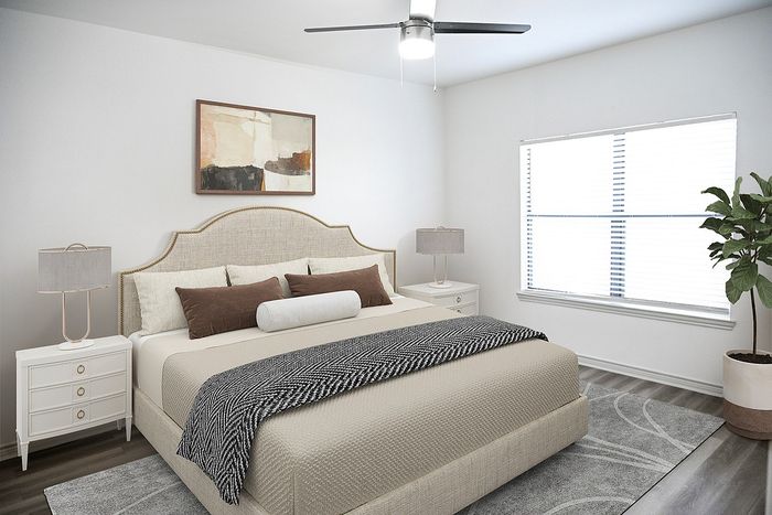 Elegant bedroom with stylish decor, featuring a plush bed, modern ceiling fan, and bright window lighting.