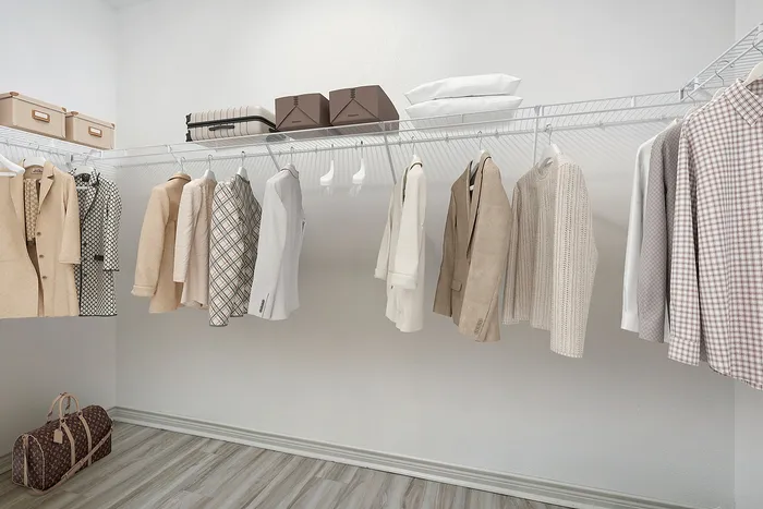 Spacious walk-in closet with elegant attire and organized shelving, offering luxurious and practical storage solutions.