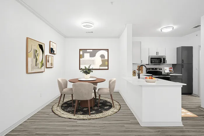 Chic modern dining area with elegant seating and contemporary art, adjacent to a sleek, fully-equipped kitchen.