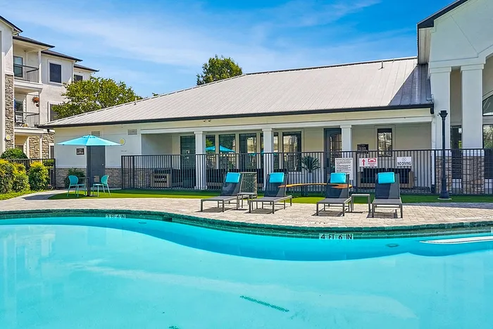 Inviting outdoor pool area with sun loungers and shaded seating, perfect for relaxation and leisure.