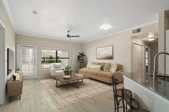 Bright and modern living room with a cozy beige sofa, elegant armchair, chic wooden coffee table, and stylish decor, offering a welcoming ambiance.