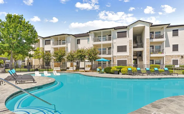 Vibrant apartment featuring a crystal-clear swimming pool, surrounded by modern lounging areas and lush greenery, ideal for relaxation and leisure.