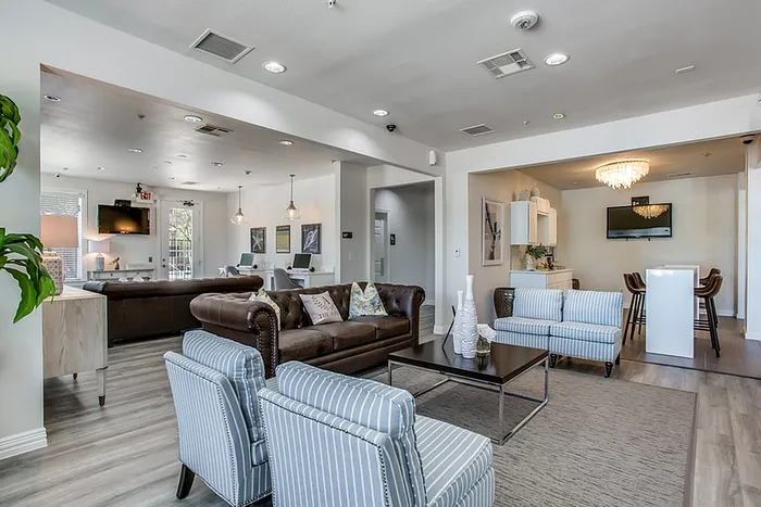 Contemporary open-concept living space featuring elegant seating, modern decor, and a stylish dining area with a chandelier.