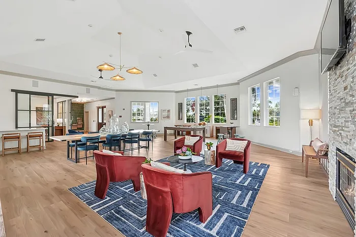 Clubhouse with chic red chairs, modern decor, and stylish lighting, perfect for relaxation and entertaining.