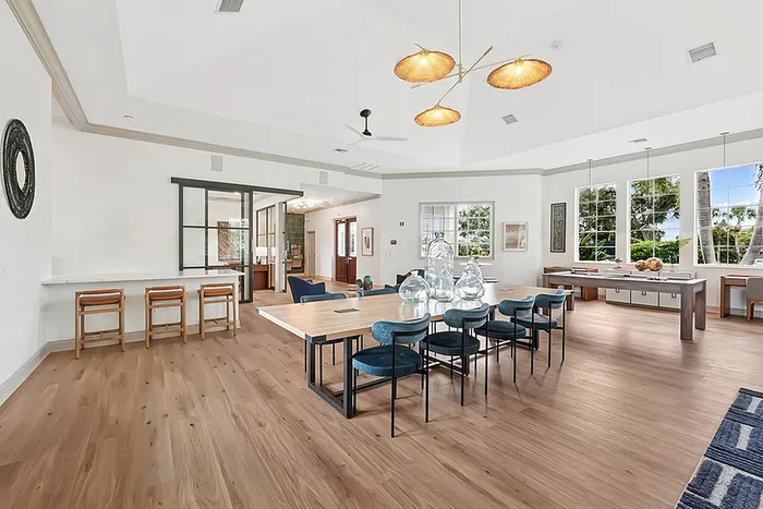 Clubhouse with elegant dining area, stylish lighting, and large windows offering scenic garden views.