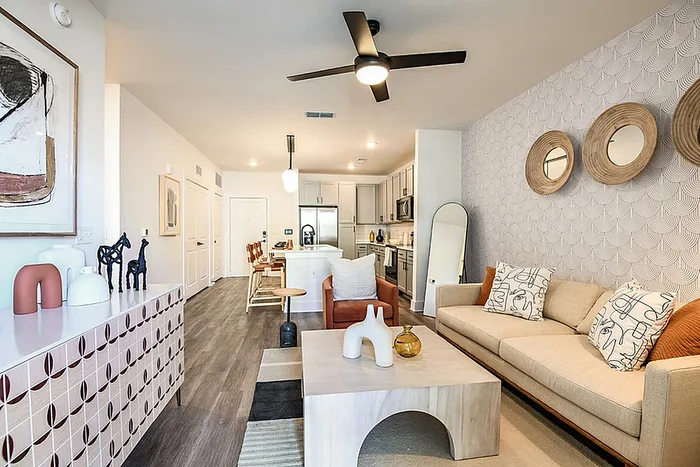Chic and modern open-concept living room and kitchen with stylish decor, hardwood-syle flooring, and contemporary lighting.