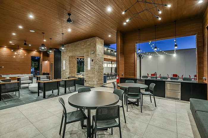 Modern lounge area with elegant wooden ceiling, stylish lighting, and ample seating for social gatherings.
