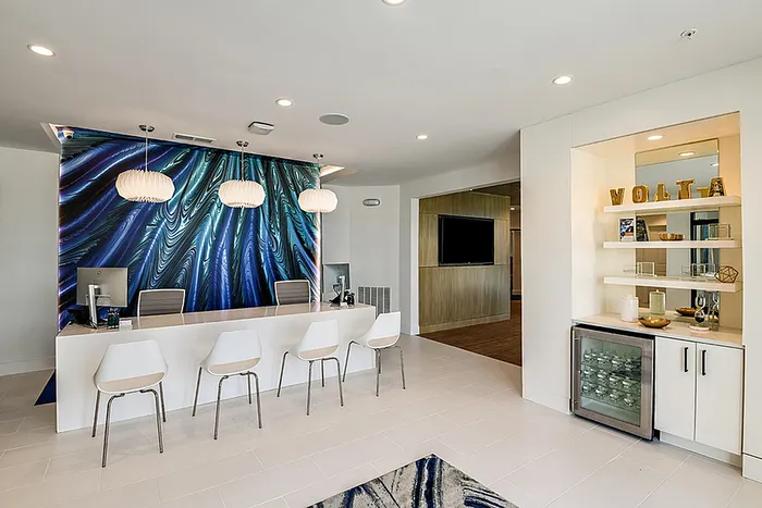 Chic modern office space featuring elegant lighting, stylish seating, and a captivating abstract wall art.